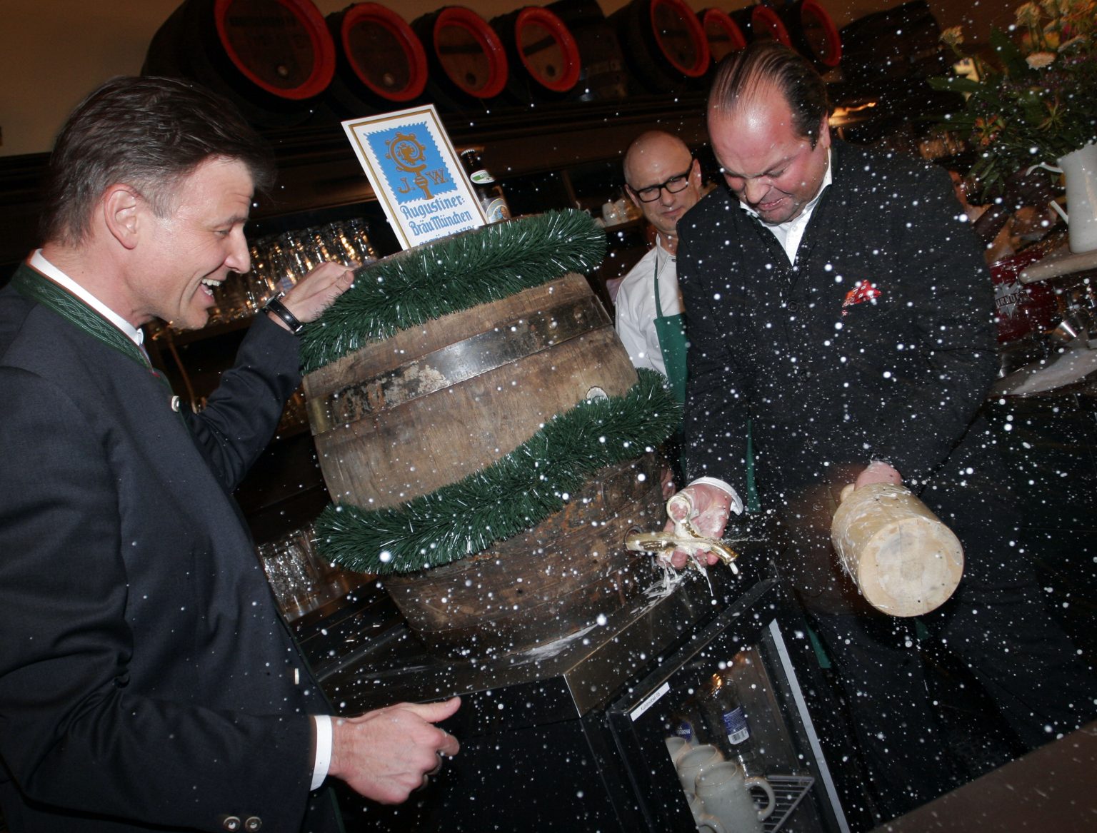 Ein Mitarbeiter bearbeitet ein großes Holzfass, während Holzspäne durch die Luft fliegen.