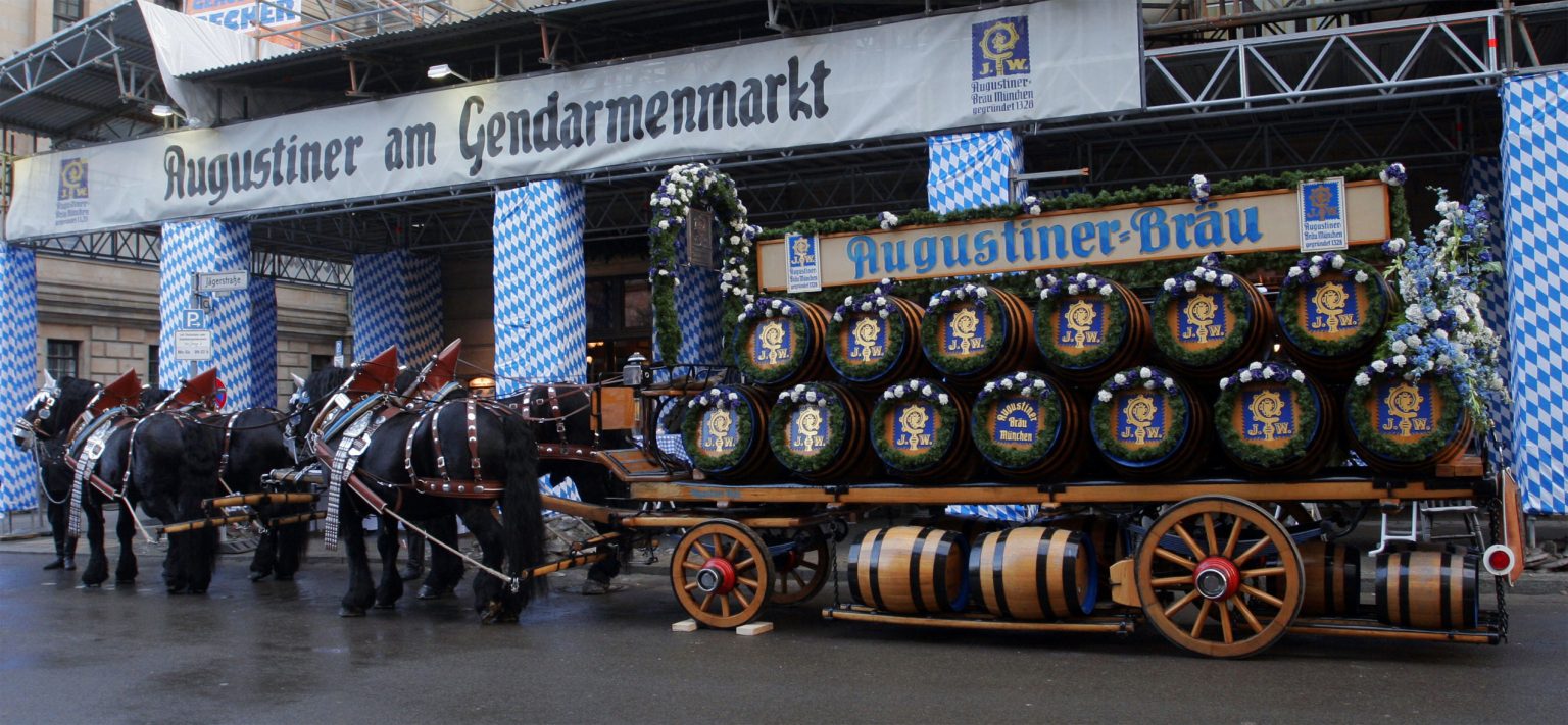 Ein traditioneller Bierwagen mit großen Holzfässern und geschmückten Pferden präsentiert sich am Berliner Gendarmenmarkt.
