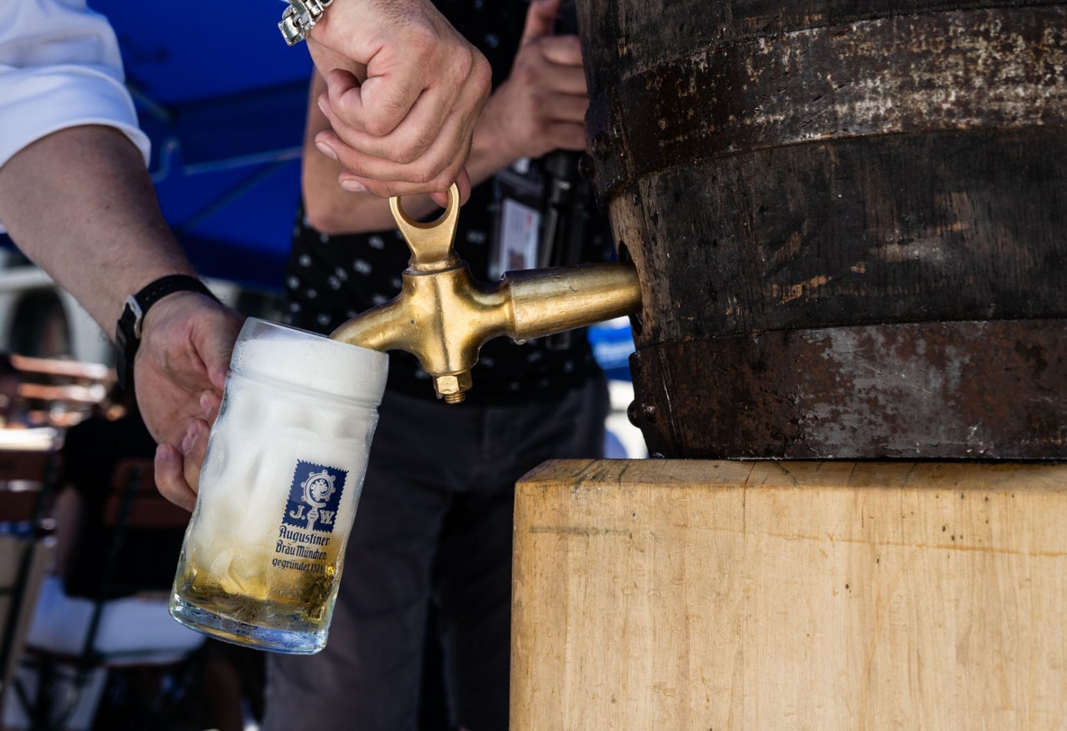 Detailaufnahme eines frisch gezapften Augustiner-Biers an einem Holzfass.